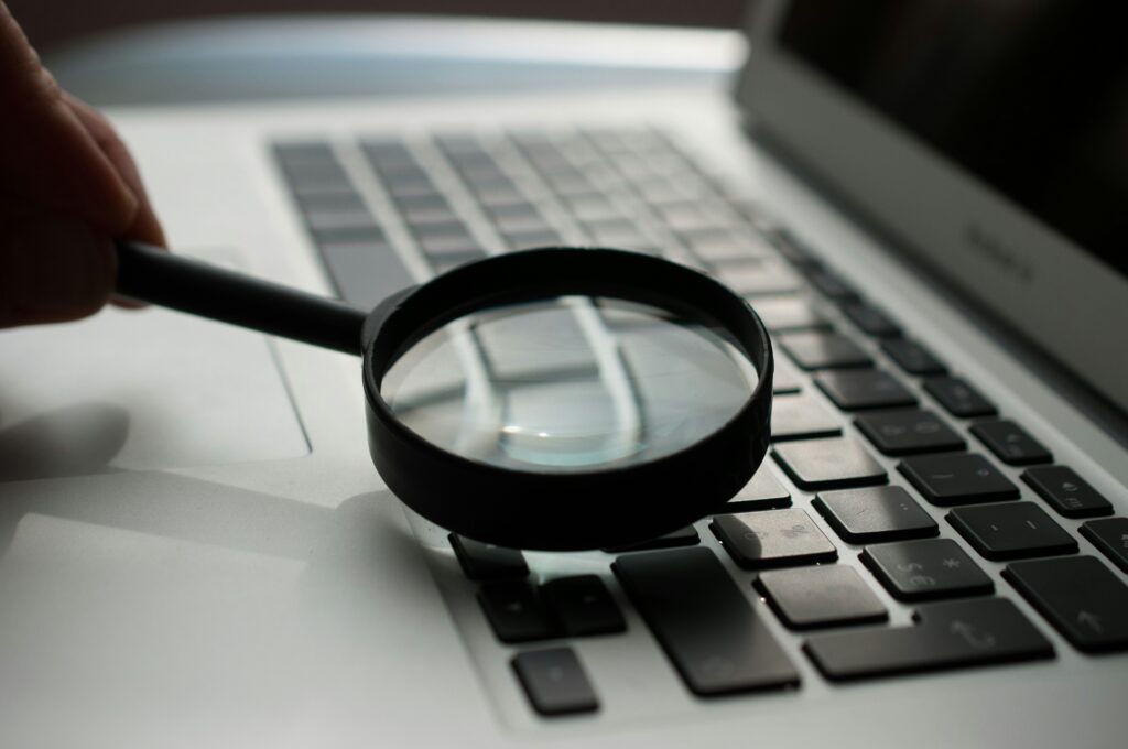 Magnifying glass on a laptop to represent keyword research