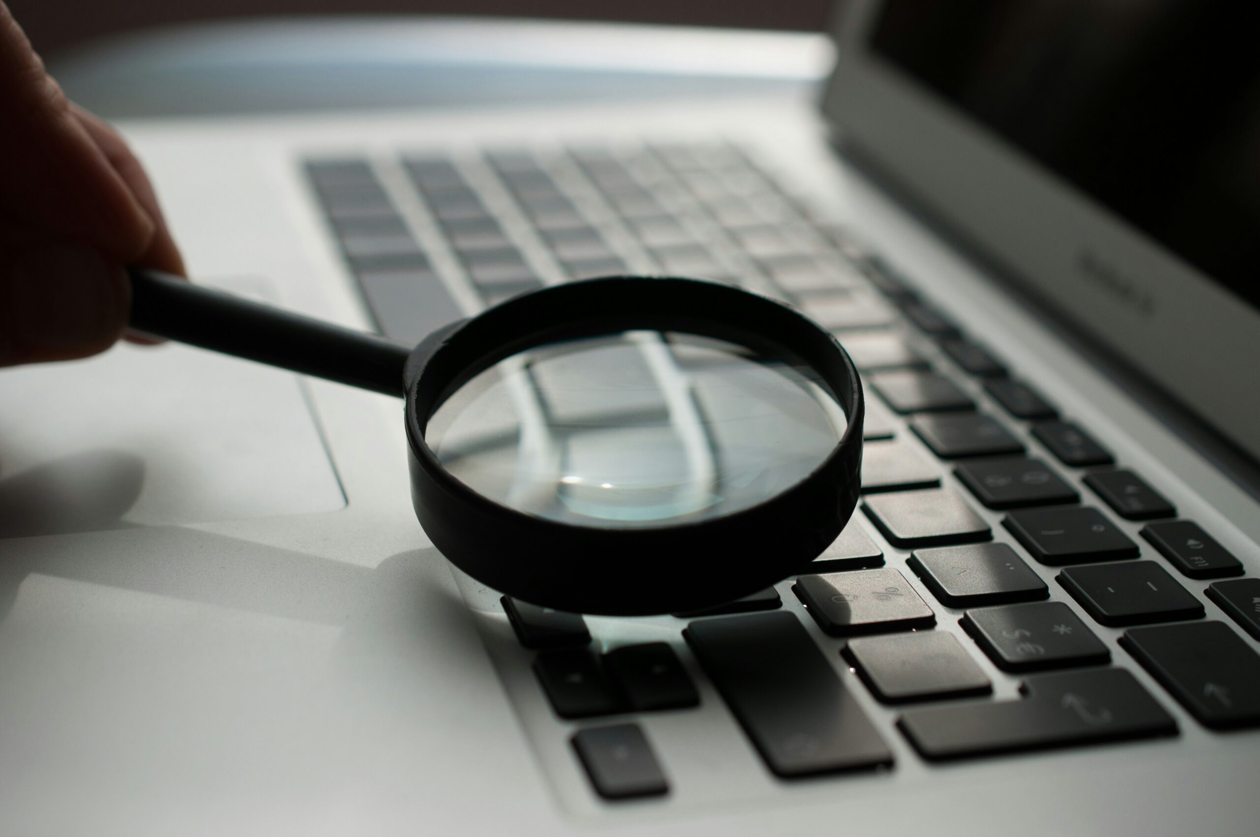 Magnifying glass on a laptop to represent keyword research