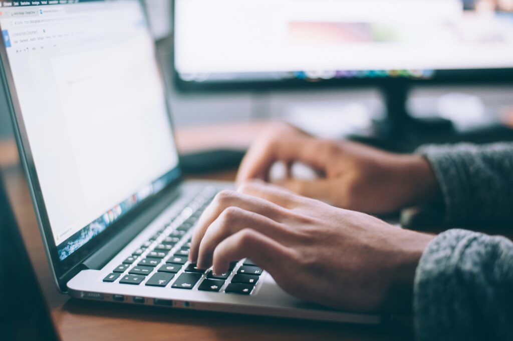 Hands typing on a laptop for a blog