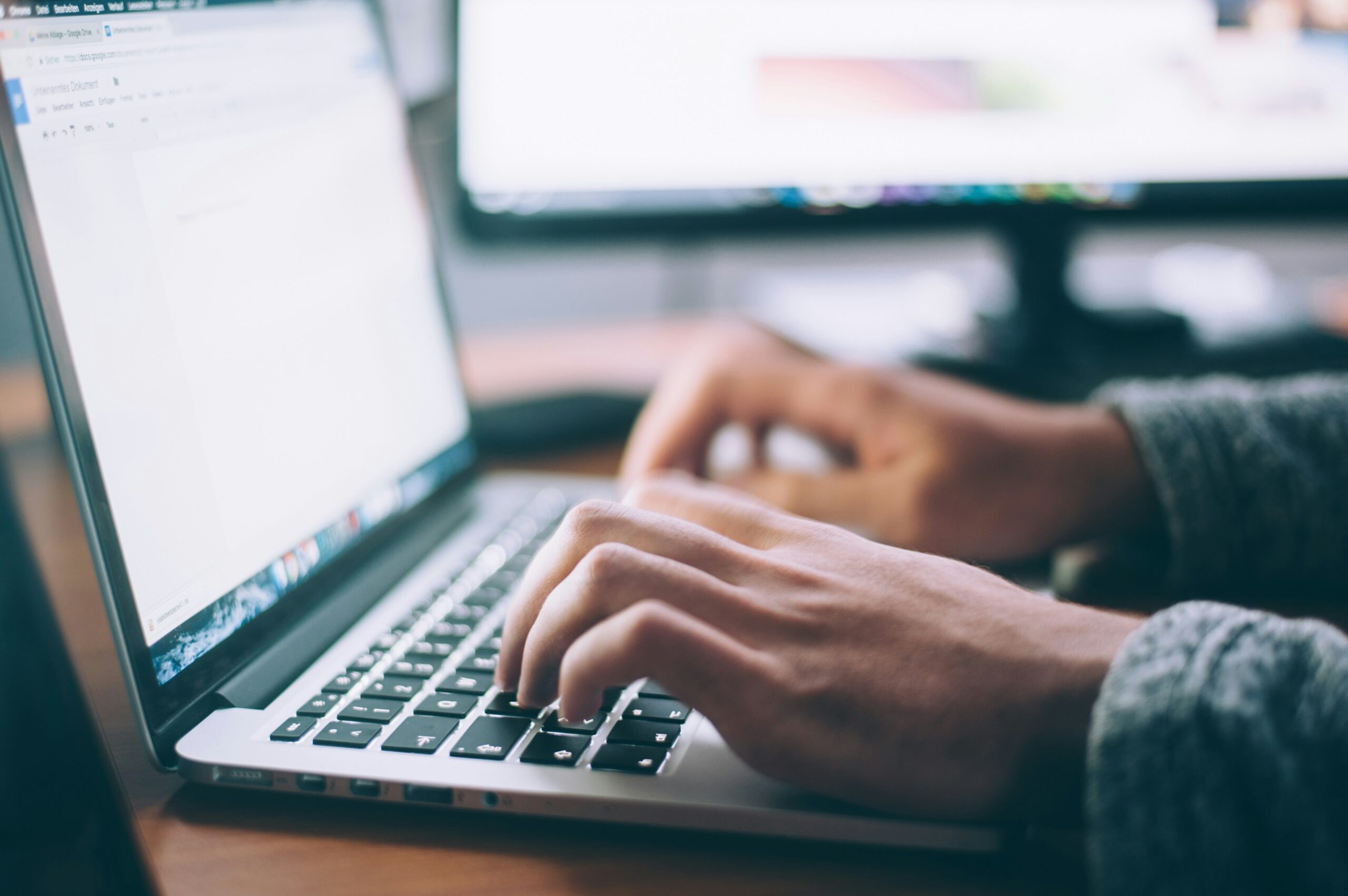 Hands typing on a laptop for a blog